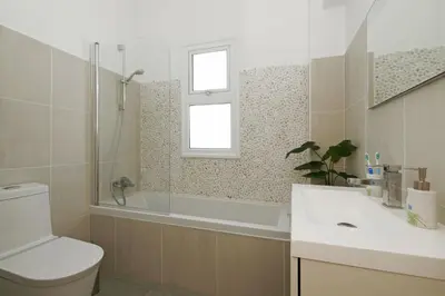 a bathroom with a tub and a toilet and a sink at Villa Blue Oasis in Protaras