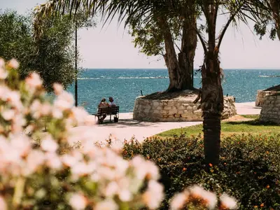 two people sitting on a bench overlooking the ocean at The Salnik Beach Apartment in Limassol