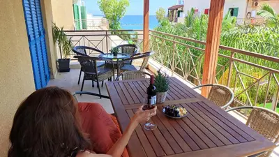 two women sitting at a table with a glass of wine at The Salnik Beach Apartment in Limassol