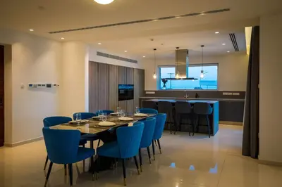 a dining room with a table and blue chairs at Love Bridge Seaview Villas in Ayia Napa