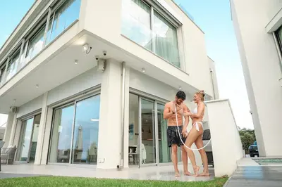 a man and a woman standing outside of a house at Mythical Villas Zeus and Venus in Protaras