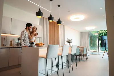 a man and a woman standing at a kitchen counter at Mythical Villas Zeus and Venus in Protaras