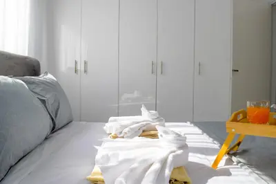 a living room with white furniture and towels on the floor at Coastal Getaway in Larnaka