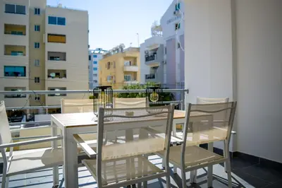 a table and chairs on a balcony with a view at Coastal Getaway in Larnaka