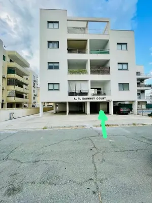 a building with a green arrow in front of it at Coastal Getaway in Larnaka