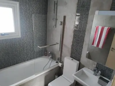 a bathroom with a toilet and a tub and a sink at Modern Suite, XL balcony, parking in Nicosia