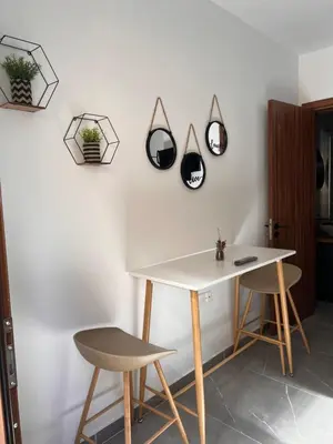 a table and two chairs next to a wall with mirrors at Maria's Apartment 2 in Galata