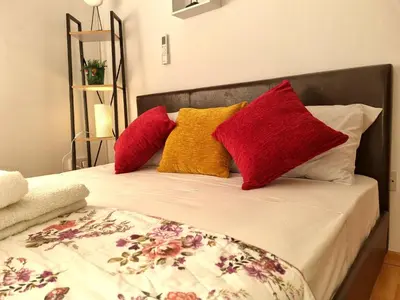 a bed with four red and yellow pillows on it at Ikaros Boutique Apartment in Limassol