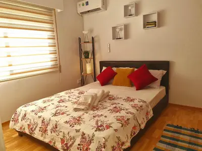 a bedroom with a bed with red and yellow pillows at Ikaros Boutique Apartment in Limassol