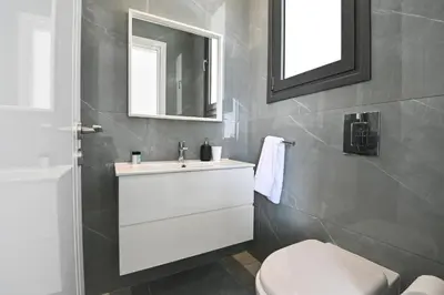 a bathroom with a white sink and a toilet at By the Beach Villa 12 in Protaras