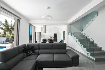 a living room with a couch and a staircase at By the Beach Villa 12 in Protaras