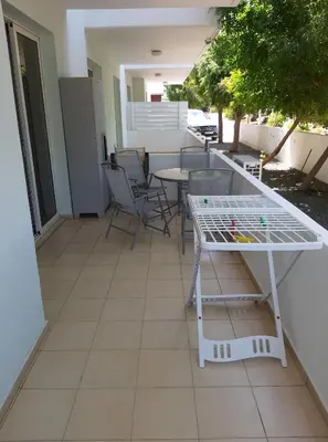 a patio with a table and chairs on a balcony at Mythical Sands Resort Ilona Apartment for families in Protaras