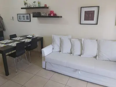 a living room with a white couch and a table at Mythical Sands Resort Ilona Apartment for families in Protaras
