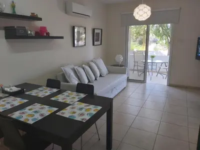 a living room with a couch and a table at Mythical Sands Resort Ilona Apartment for families in Protaras