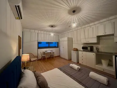 a bedroom with a large bed and a kitchen at RHEA Studio Down Town Nicosia in Nicosia