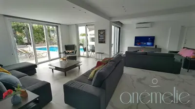 a living room with couches and a tv and a pool at anemelie in Sotira