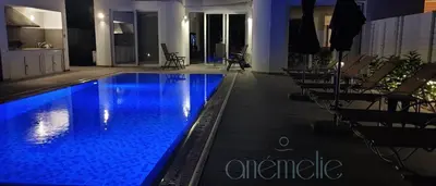 a swimming pool with blue water in a building at anemelie in Sotira