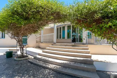 a set of stairs in front of a building with trees at Villa Amelia by Ezoria Villas in Pervolia