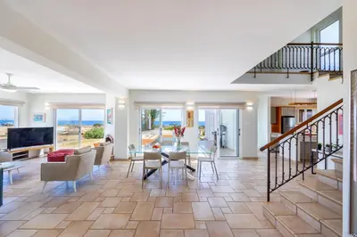 a dining room and living room with a table and chairs at Protaras Seafront Villa Violetta in Protaras