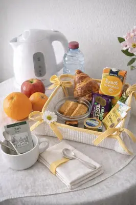 a breakfast tray with breakfast foods and a tea kettle at The Tony Hotel in Nicosia