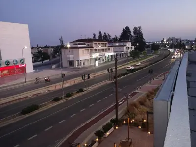 a city street at night with cars on the road at Kalidonia “PANORAMA” STUDIO APARTMENT in Engomi