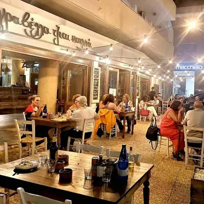 a group of people sitting at tables in a restaurant at Kalidonia “PANORAMA” STUDIO APARTMENT in Engomi