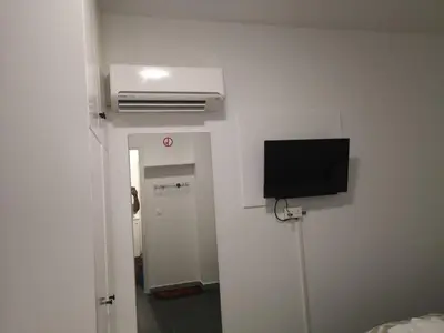 a room with a tv on the wall and a hallway at Kalidonia “PANORAMA” STUDIO APARTMENT in Engomi