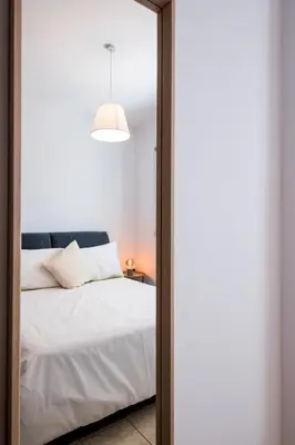 a bedroom with a white bed and a mirror at Pebble Beach Apartment in Voroklini