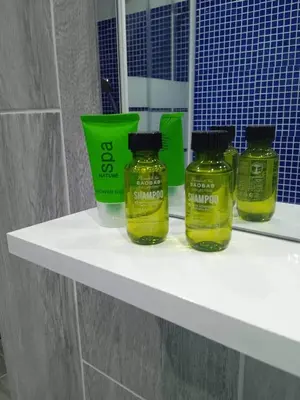 three bottles of honey on a shelf in a bathroom at Adorable Cozy Apartment in Aglantzia