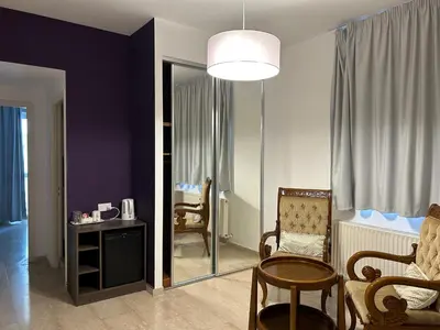 a living room with a chair and a table at St Elena Boutique Residence in Larnaka