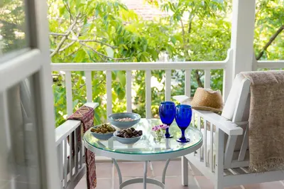 a table with blue glasses and bowls of food on a porch at Ample Places in Pano Lefkara