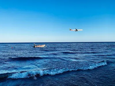 a small boat and a plane in the ocean at BALI SUITES 101 in Larnaka