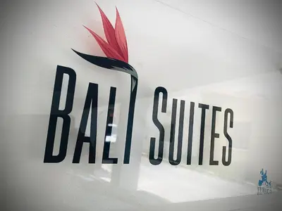 a sign on a wall with a red and black logo at BALI SUITES 101 in Larnaka