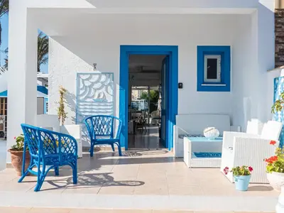 a blue door on a house with blue chairs at Greek Island Style 2 bedroom Villa with Pool next to the Sea in Larnaka