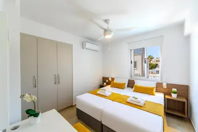 a white bedroom with a large bed and a window at Villa Lantos Central Protaras in Protaras