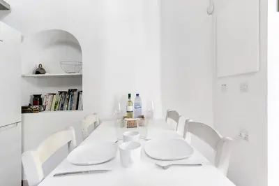 a white dining room with a white table and chairs at To Hani - Large Traditional House in Nicosia