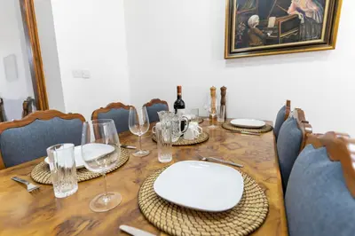 a wooden table with plates and wine glasses on it at To Hani - Large Traditional House in Nicosia