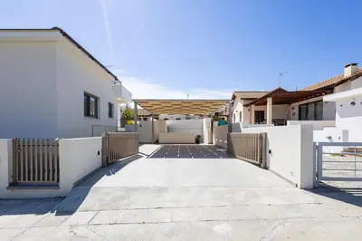 a walkway between two white buildings with a fence at Villa Pacy in Ayios Theodhoros