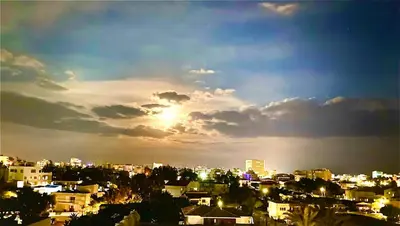a view of a city with the sun setting at BALI SUITES 303 in Larnaka