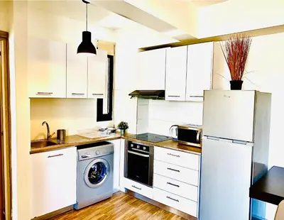 a kitchen with a white refrigerator and a dishwasher at BALI SUITES 404 in Larnaka