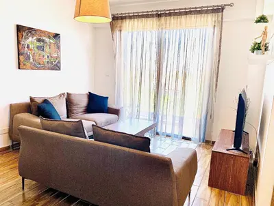 a living room with a couch and a tv at BALI SUITES 404 in Larnaka