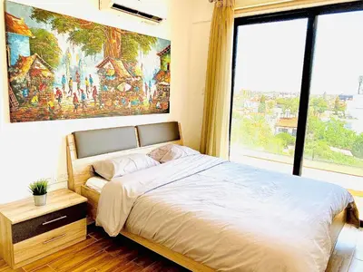 a bedroom with a large bed and a large window at BALI SUITES 505 in Larnaka