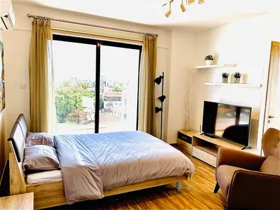 a bedroom with a bed and a large window at BALI SUITES 505 in Larnaka