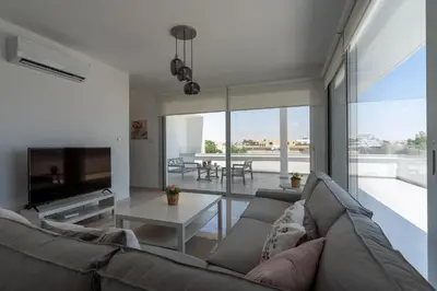 a living room with a couch and a table at Harmonia 2-BR Apt in Livadia in Larnaka
