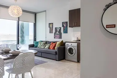 a living room with a couch and a table at Bonne Heure 1-BR Apt in Larnaca in Larnaka