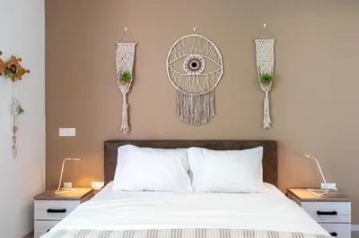 a bedroom with a bed with white sheets and an eye on the wall at Bonne Heure 1-BR Apt in Larnaca in Larnaka