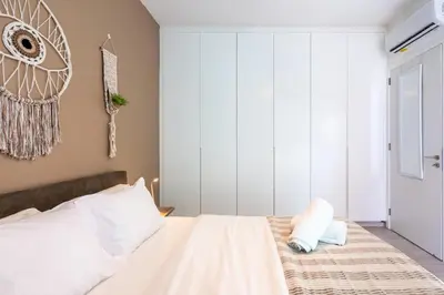 a bedroom with a bed with white sheets and pillows at Bonne Heure 1-BR Apt in Larnaca in Larnaka