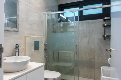 a bathroom with a glass shower and a sink at Bonne Heure 1-BR Apt in Larnaca in Larnaka