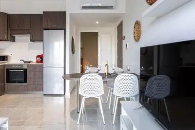 a kitchen with a table and chairs in a room at Bonne Heure 1-BR Apt in Larnaca in Larnaka