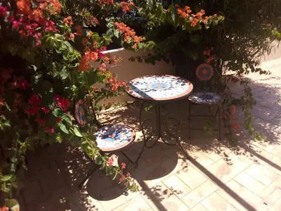 two chairs and a table in front of some flowers at Summer Breeze - Cheerful 2 bedroom villa with pool in Ayia Napa